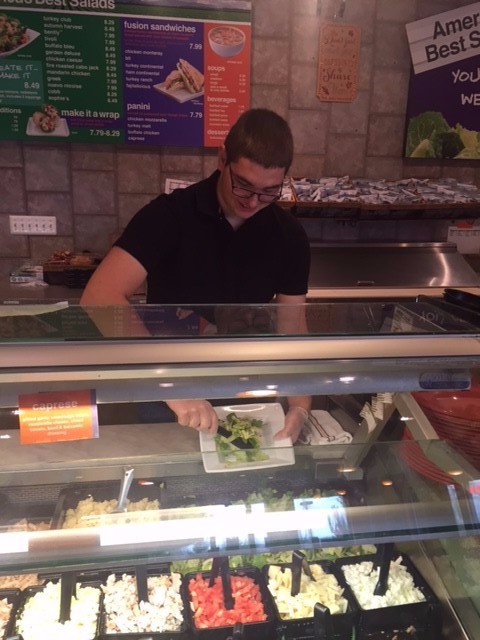 Sophomore Louis DiGirolamo serves up one of his handcrafted salads at SaladWorks. 