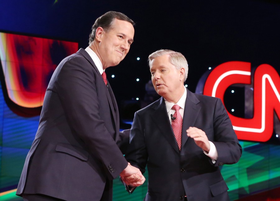 GOP presidential candidates, Sen. Rick Santorum, left, and U.S. Sen. Lindsey Graham take the stage during the CNN Republican presidential debate at the Venetian in Las Vegas on Tuesday, Dec. 15, 2015. 