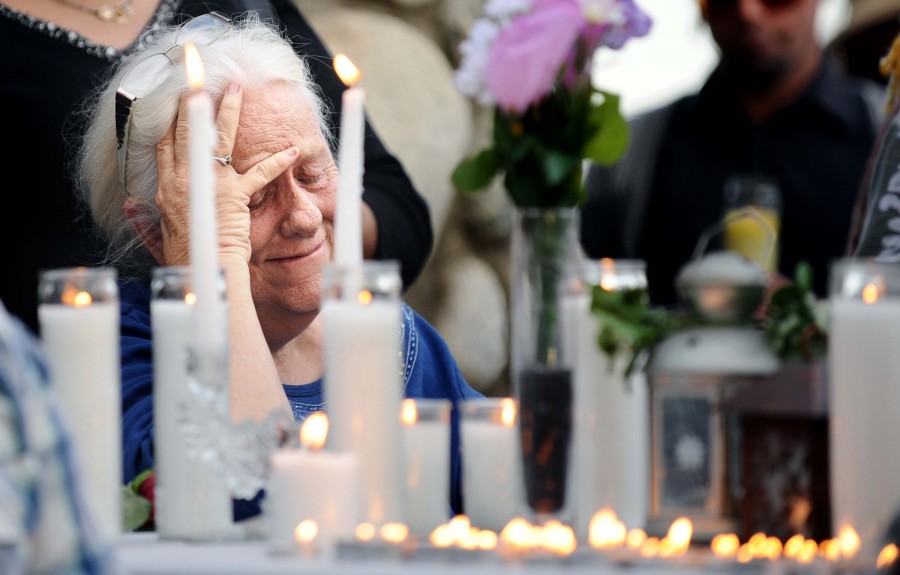 A woman cries during a memorial for San Bernardino shooting victim Daniel Kauffman at the Sante Fe Dam in Irwindale, Calif., on Saturday, Dec. 5, 2015.