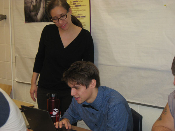 Special education teacher Maria Padilla Davis helps senior Robert Briant during the Hour of Code event earlier this month.