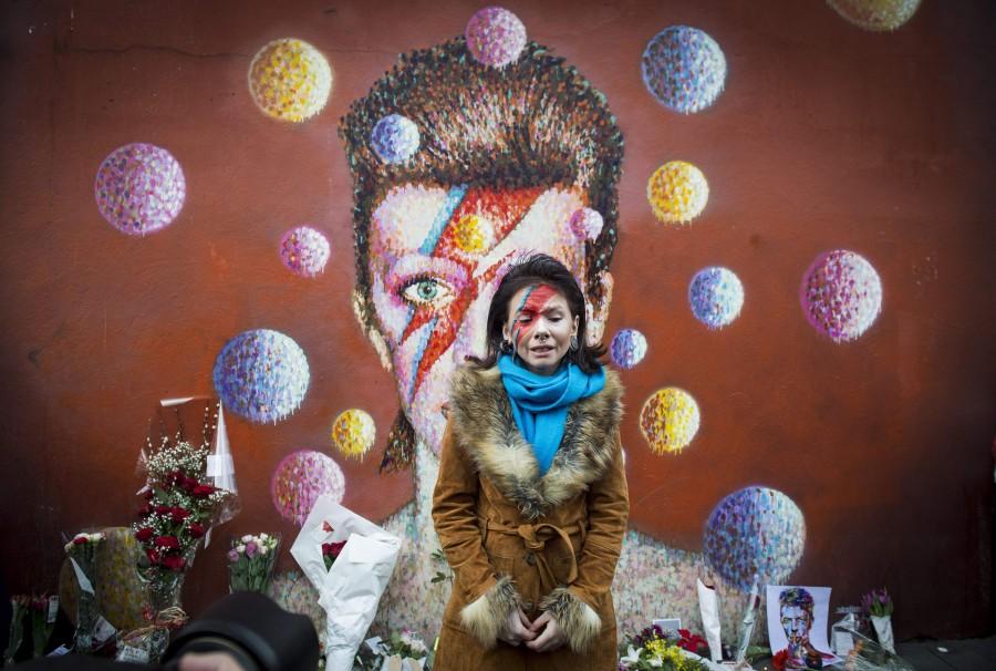 A fan visits the mural of David Bowie in Brixton where the star grew up, to pay her respects, on Jan. 11, 2016 in London. 