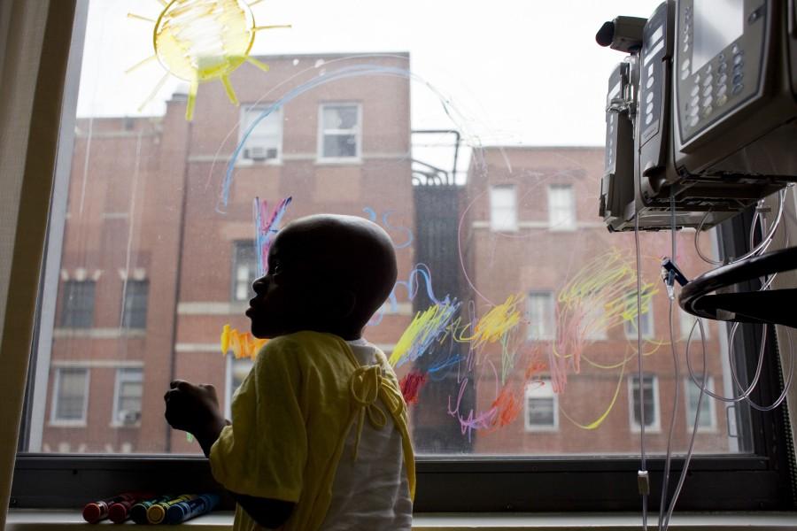 Kya, 4, draws on the window of her hospital room during another round of chemotherapy at Rush University Medical Center, March 29, 2011, in Chicago, Illinois. 