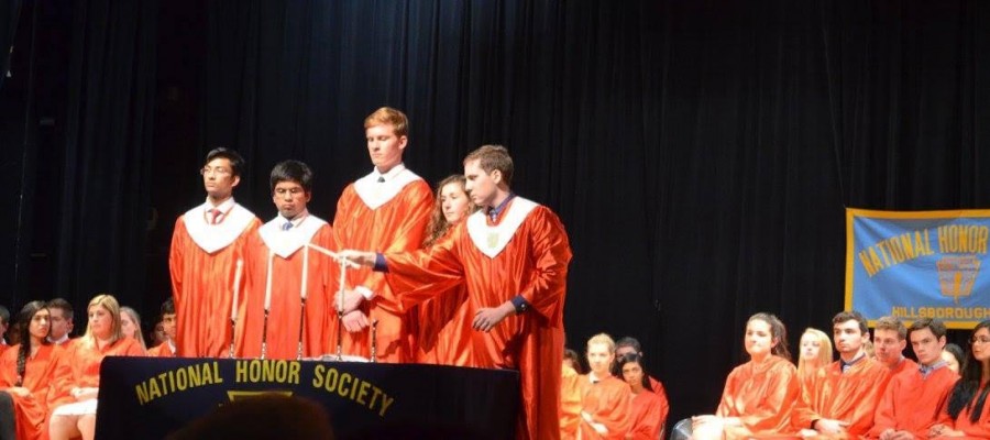 NHS Vice President Ben Trybulski lights a candle at this year's induction ceremony while fellow officers oversee the ceremony. The officers from left to right include Viswajit Kandula, Viral Shanker, Phil Masiakowski, and Olivia Delorenzo.