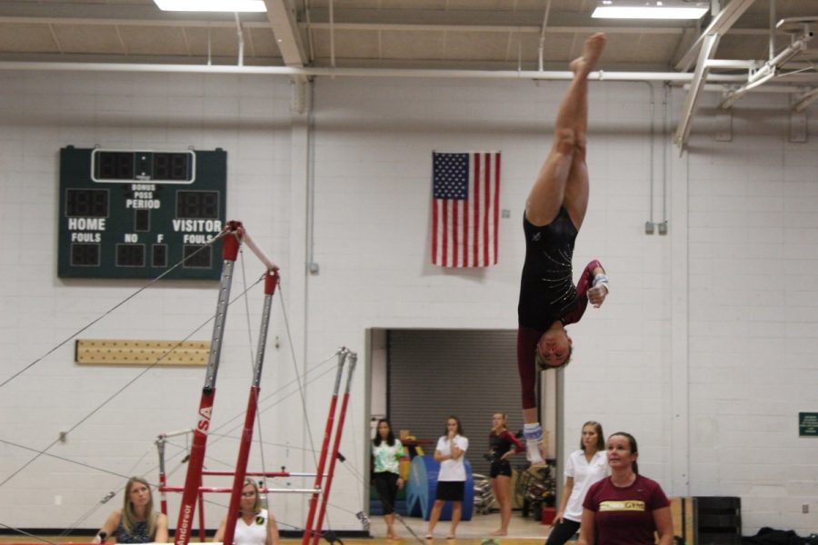 Sophomore Brielle Seidel prepares to land her dismount as head coach  Beth Murrin oversees the action.