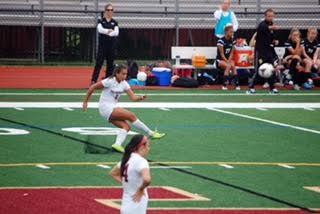 Junior Amelia Curtis kicks the ball into the opponent's territory. 