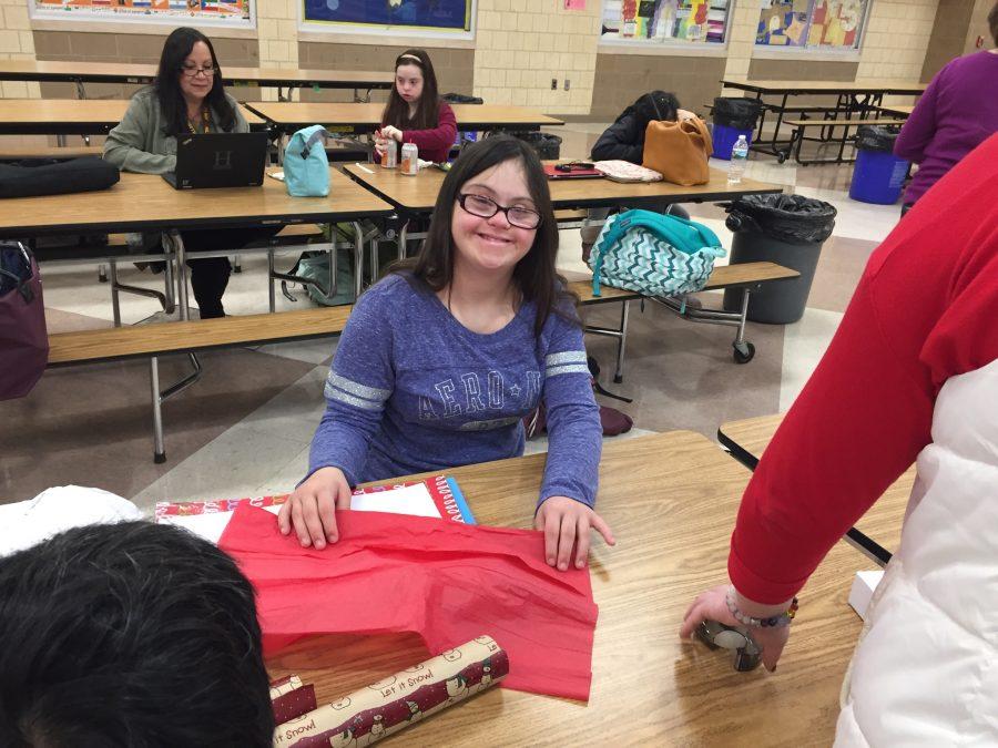 Elena Mazzeo wraps her holiday purchases with the help of Peer Plus students.