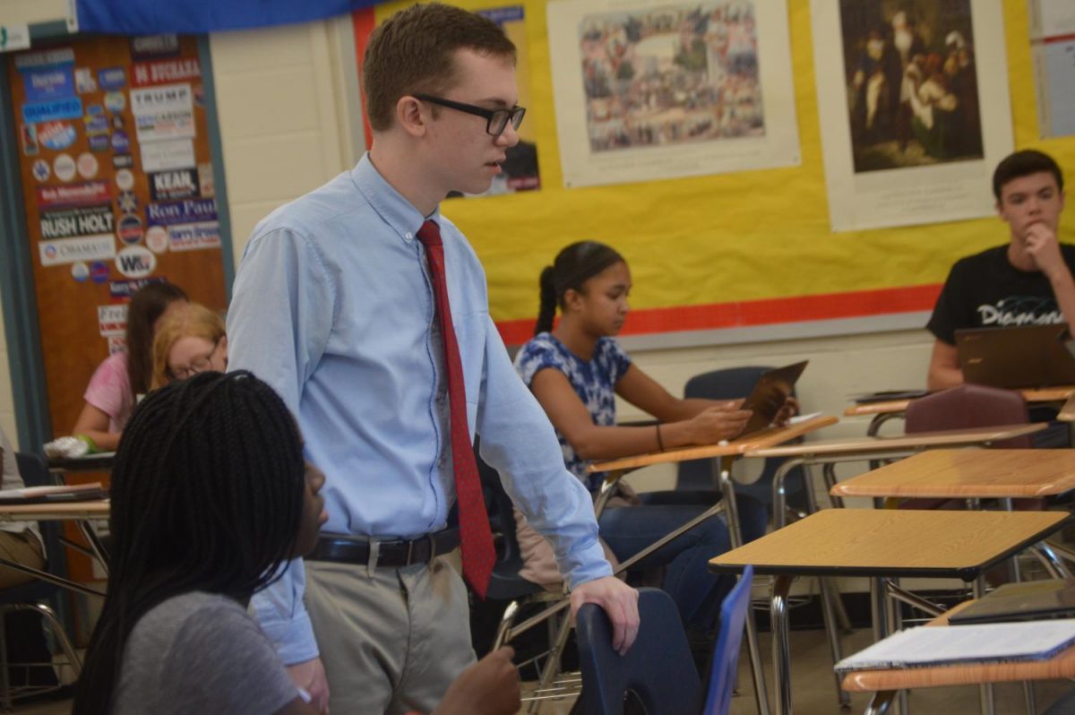 TCNJ senior Nelson Kelly works his magic under the supervision of history teacher Robert Fenster.