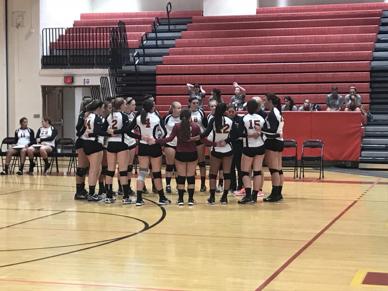 The volleyball team pays close attention as head coach Cheryl Iaione talks to them before a match. 