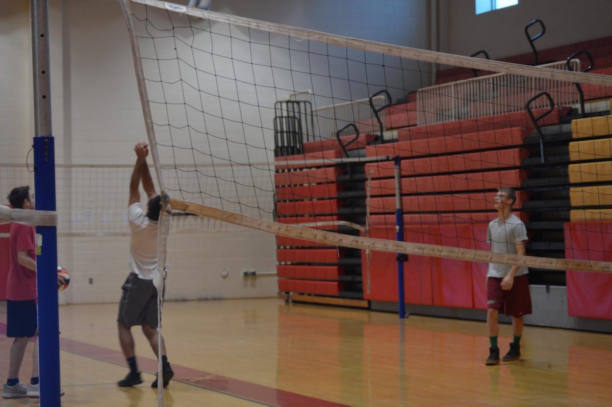 Senior Michael  Dooley prepares to send the ball over the net in gym class. Dooley and his fellow Raiders are still adjusting to the new gym policy rolled out this year.