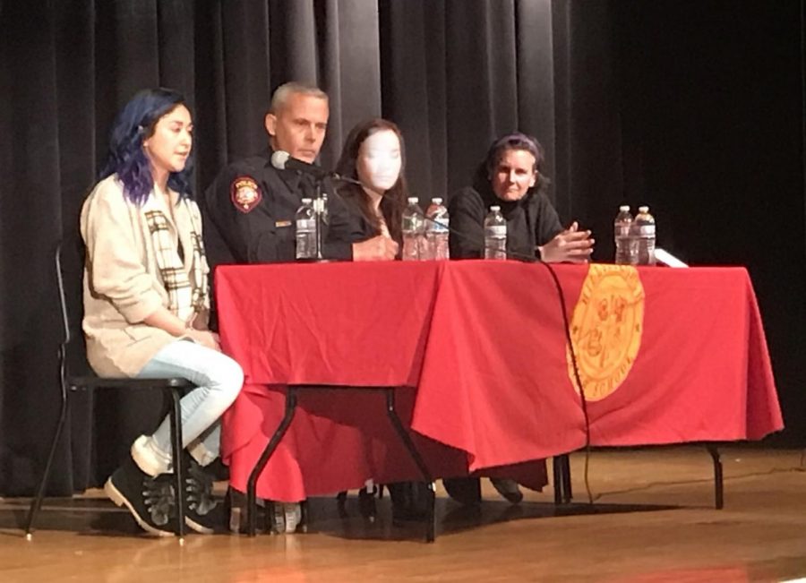 Panel of speakers awaits questions from students during the "Chasing the Dragon" assembly.