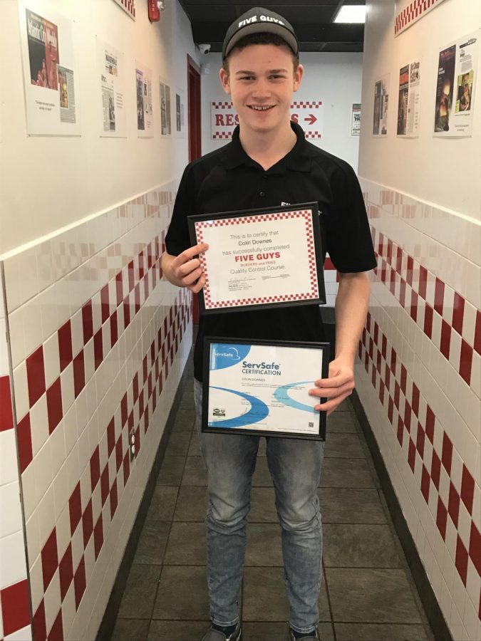 Senior Colin Downes shows off his certifications that help grant him the opportunity to be a manager at Five Guys.