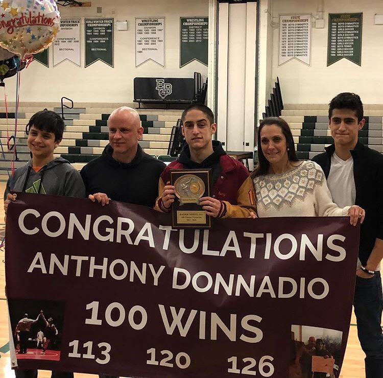 Senior Anthony Donnadio stands proud with his family after his 100th win.