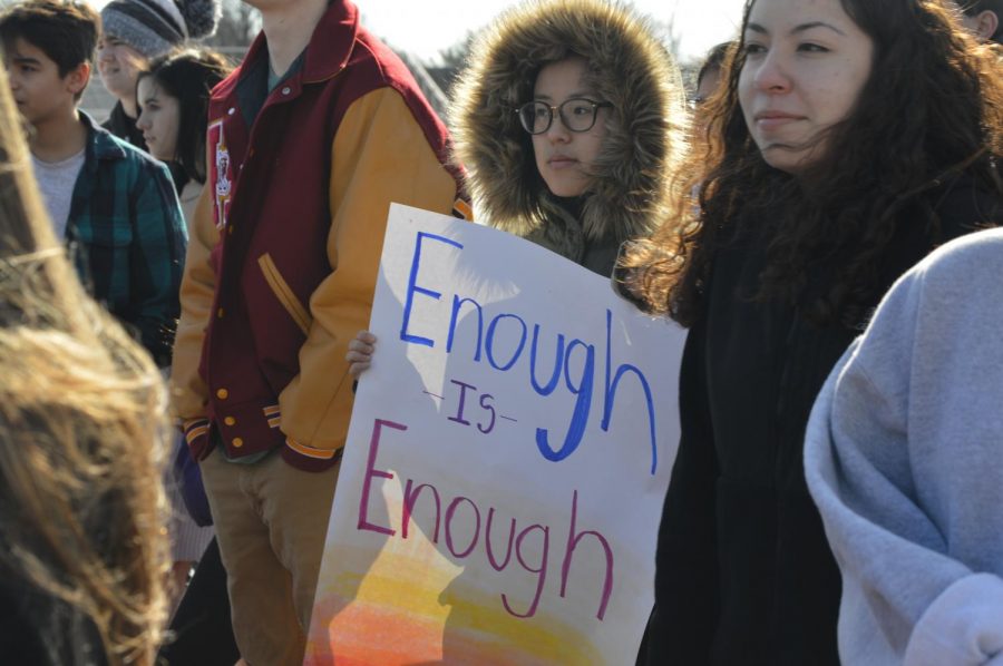 Senior Ashley Yang holds a sign that reads "Enough is Enough."