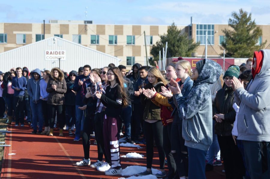 Students applaud the leaders of the walkout. 