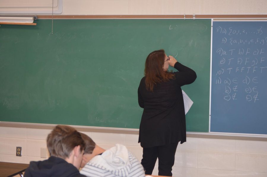 Math teacher Bonnie Keating erases the chalkboard preparing to teach her class another lesson.
