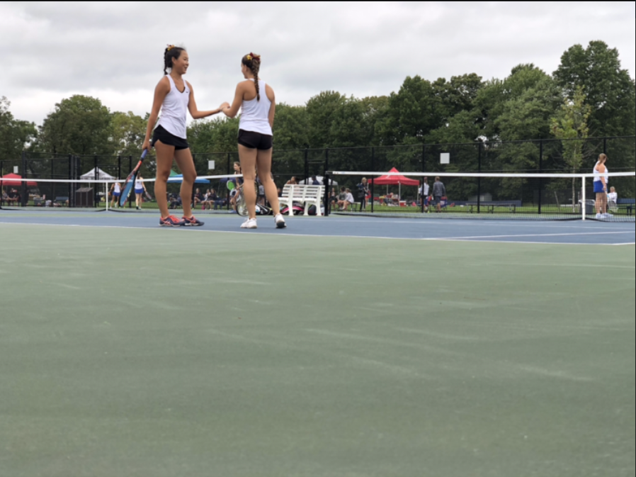 Seniors Hanna Kim and Cynthia Puleo celebrate winning a point in a recent doubles match.