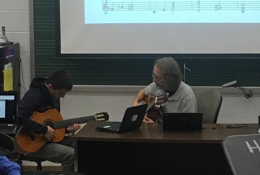 Music teacher Jonathan Klizas instructs senior Gavin Tyman on the guitar.