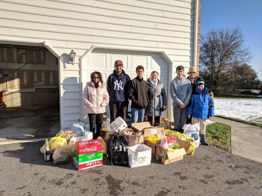 Aruna Dontabhaktuni, Tejas Patel, Miraj Vakil, Eileen Candelaria, Dean Milano, Robert Milano, and Devon Milano stand behind the food collected to be donated to families in need.