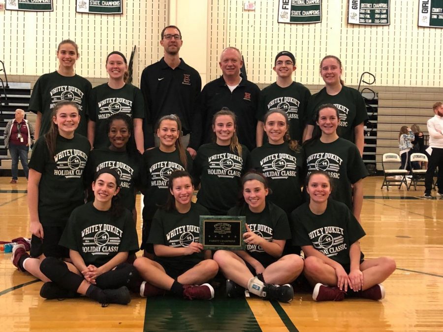 The Lady Raiders and head coach Ian Progin pose with their well-deserved championship hardware after winning the holiday tournament.