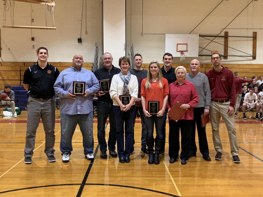 Past and current Hillsborough coaches pose with former players after being honored.