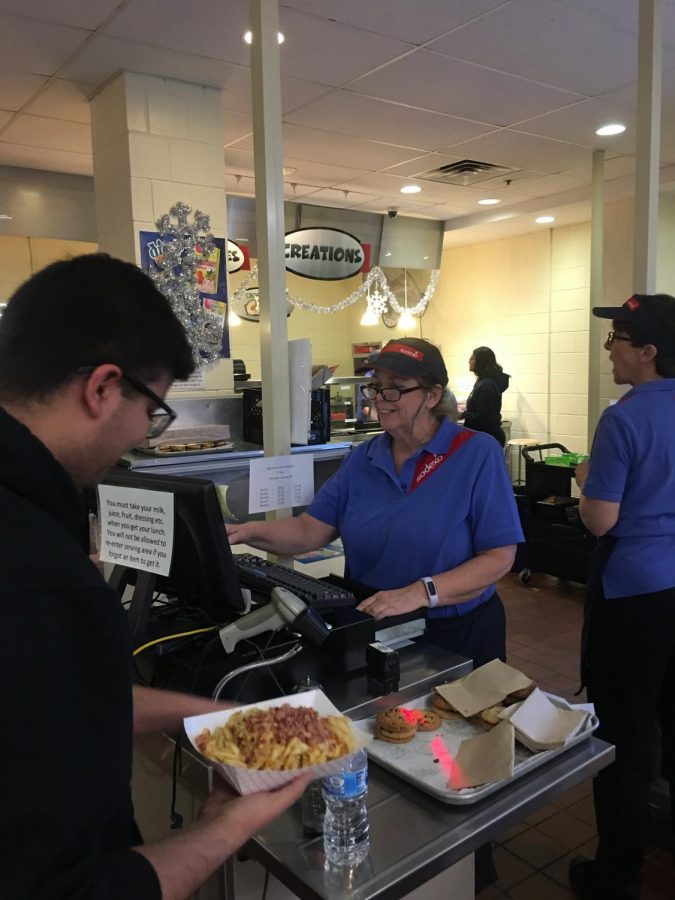 Senior Karan Desai buying lunch with Mrs. Lynch behind the register.