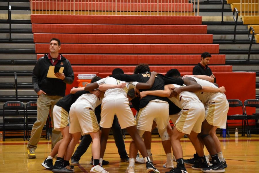 The varsity boys basketball team huddles before battling on the hardwood.