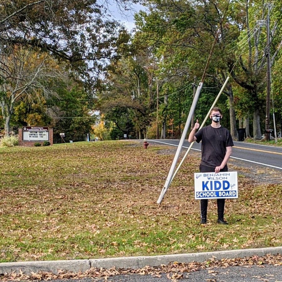 Senior Benjamin Kidd puts up one of his many signs outside of Sunnymead Elementary School, where he started his Hillsborough Education.