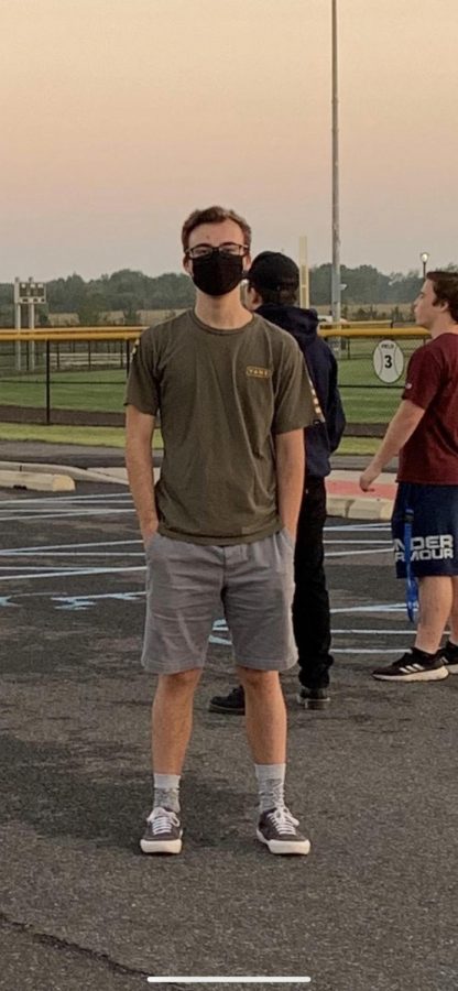 HHS senior, Sam Renz, utilizes his face mask during a group activity outside. 