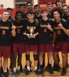 Members of the boys volleyball team pose with a trophy from the 2018 season.