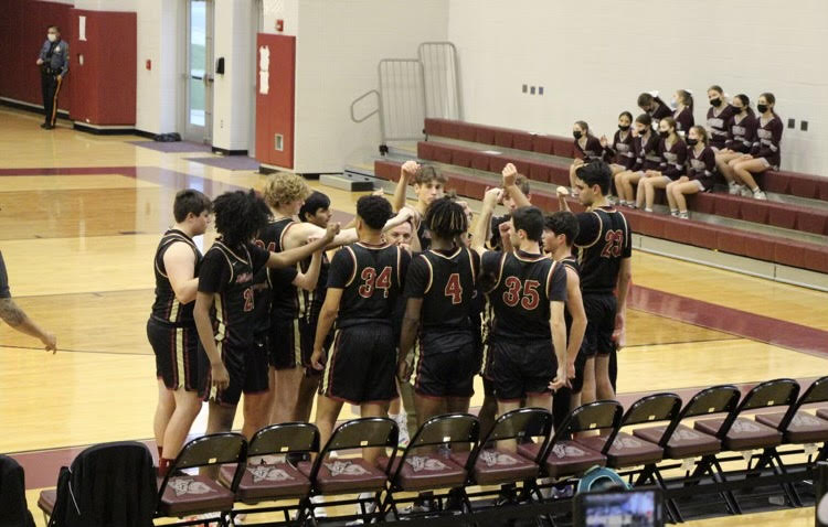 The Varsity team huddles together before the start of their game. 