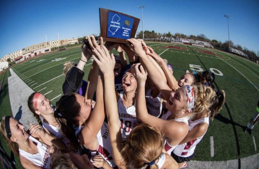 The team celebrates their state win, holding up the official NJSIAA hardware.