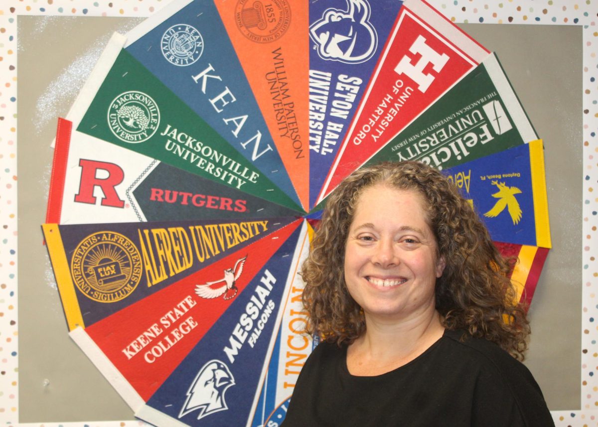 Mrs. Thomson in her office with her myriad of college pennants.