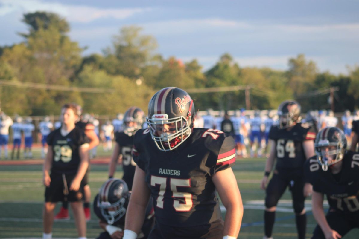 Senior Offensive Linemen Joseph Battoglia prepares for a warm up drill by getting set in his position.