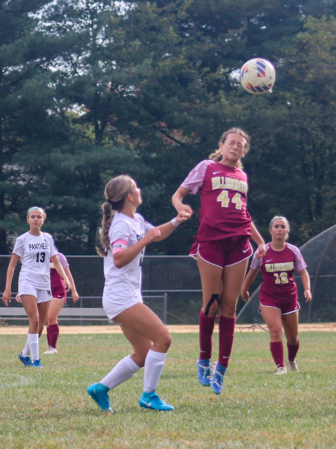 Freshman Cami Miller headbutts the ball to her teammate to get it away from rival Panthers players.
