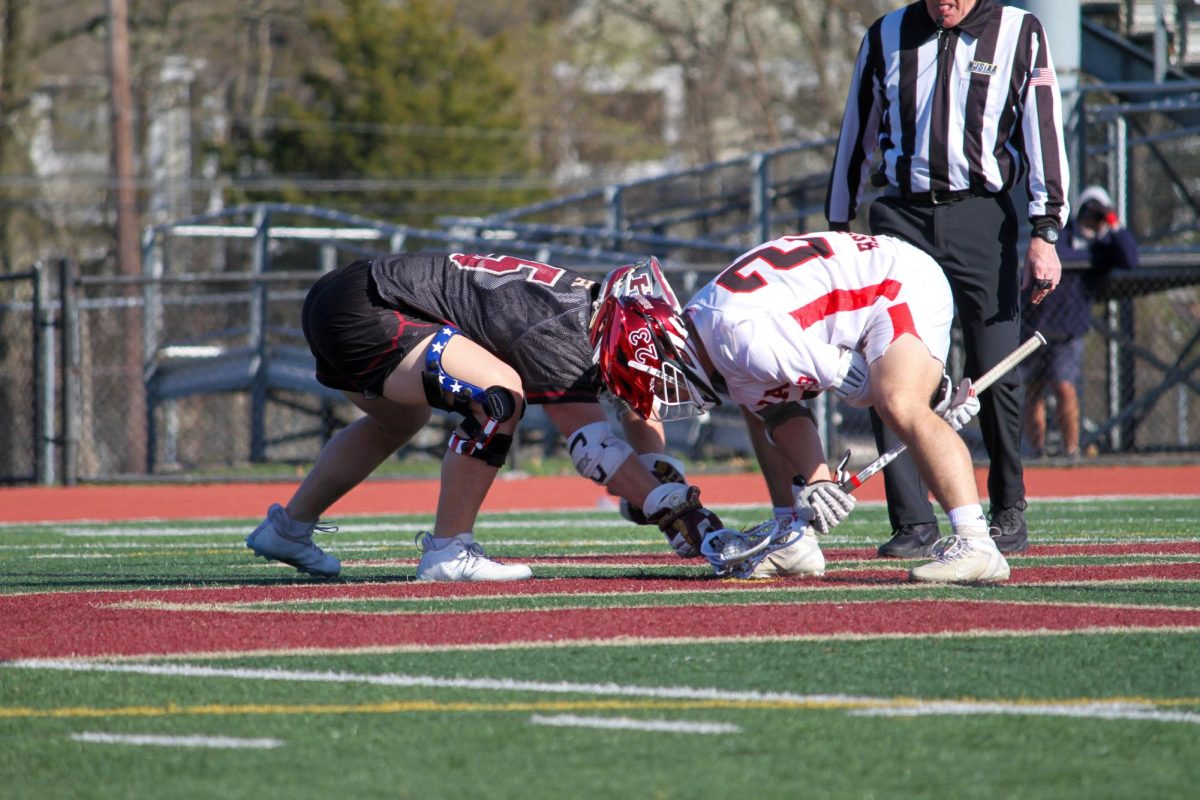 Senior Garrett Meyer faces off against a player from Hunterdon Central to start the game. Hillsborough defeated Hunterdon Central 9-6 on April 9. 