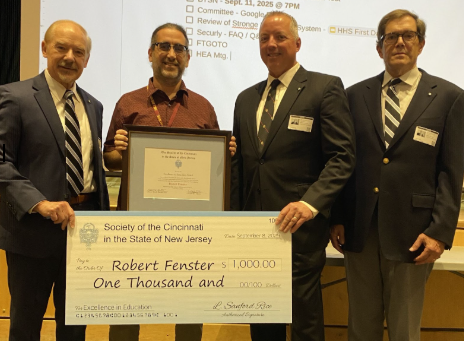 The Society of the Cincinnati presents Robert Fenster a check and certificate for his research  at a high school staff meeting.

