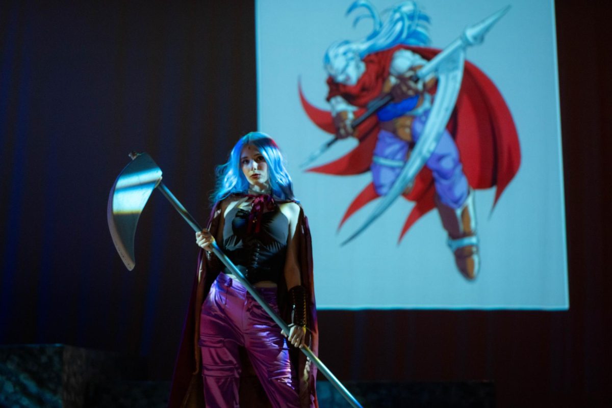 Lillith (played by Katherine Whitman) holds a spear during a fight scene.