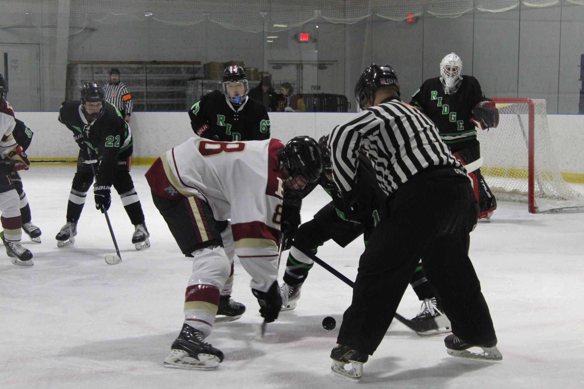 Senior Colin Marley fights for the puck in an intense face off with a Basking Ridge player, looking for an open teammate.