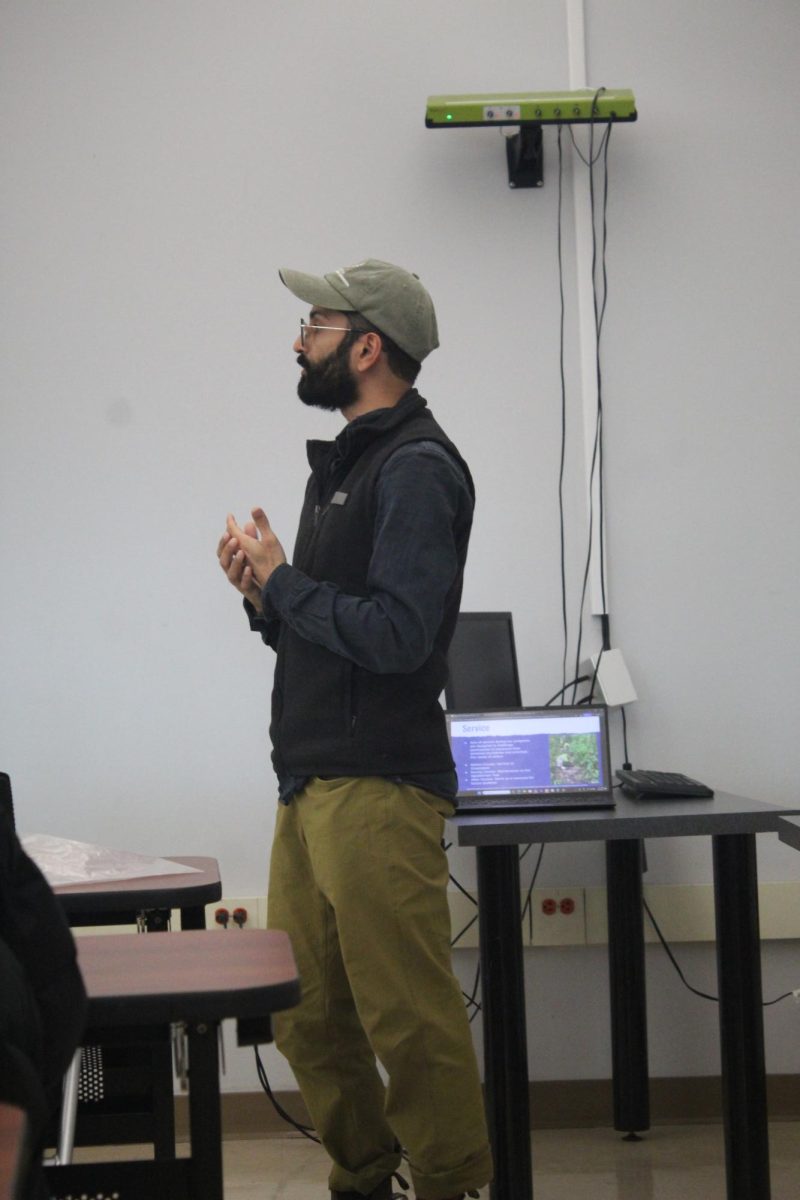 Ritam Chakraborty standing and presenting for students during the Interest Meeting.
