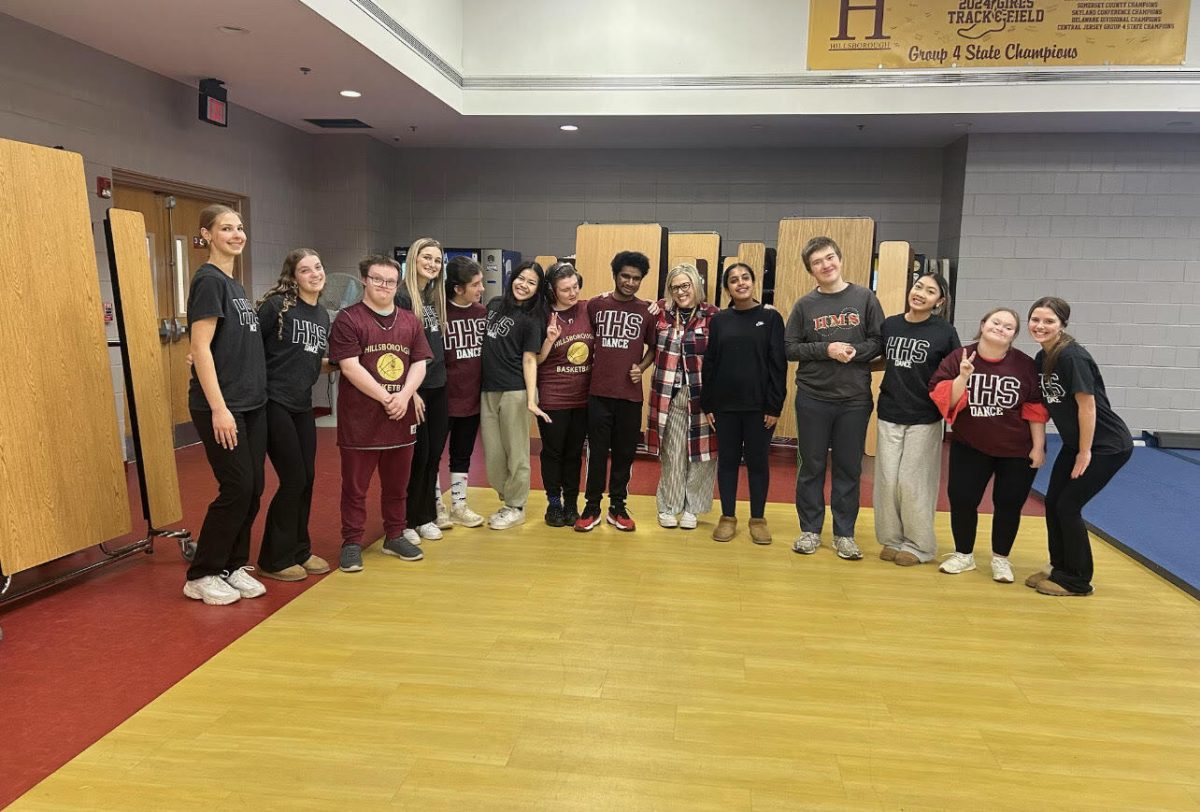 The Unified basketball team shows off their jerseys before their first game of the season, posing with Unified Dance getting ready to perform and cheer them on.